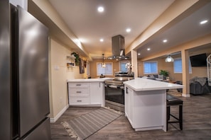 A modern kitchen with a central island, built-in oven, and stainless steel appliances. - Muskoka Waterfront Cottage - HOT TUB & SAUNA (Bala)