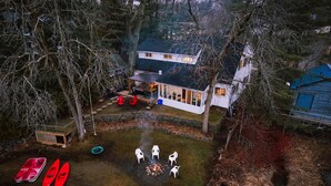 Ein Haus mit einer Terrasse, einer Feuerstelle und Sitzgelegenheiten im Freien.