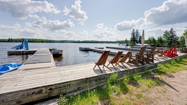 A wooden dock with boats, lounge chairs, and a small pool. - Lake Cecebe Retreat #6- Maijac Resort & Marina (Burk`s Falls)
