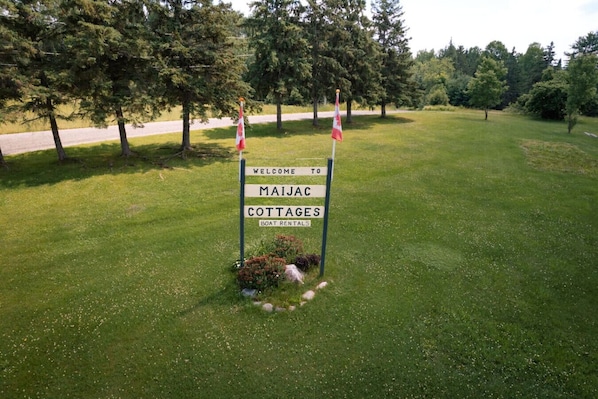 A sign welcoming to Maijac Cottages with a mention of boat rentals.
