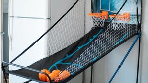 En basketkorg med nät, ett kylskåp och en blå vägg.