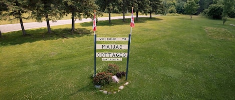 Un panneau indiquant l’entrée de Maijac Cottages et mentionnant la possibilité de louer des bateaux.