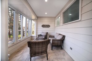 A covered porch with wicker furniture, large windows, and a sign reading 'The Porch.'
