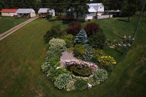 A residential area with houses, a well-maintained lawn, and a circular garden with a fountain.