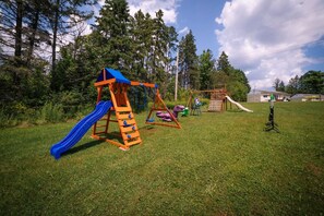 Un parque infantil con tobogán, columpios y estructuras para escalar.