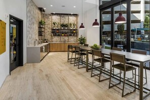 Een moderne keuken met een houten aanrechtblad, een inbouwkast met planten en hanglampen.
