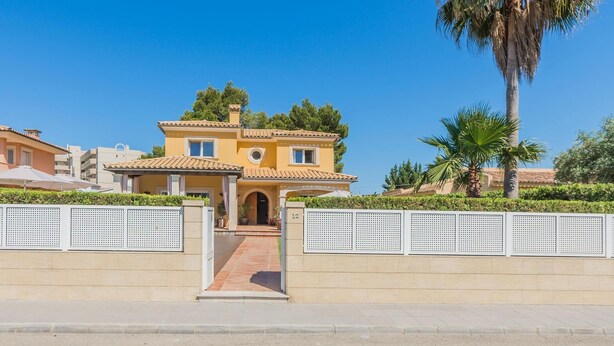 A two-story house with a tiled roof, a central entrance, and a gated driveway. - Waterfront Port D'alcudia Villa for 8 (Alcúdia)
