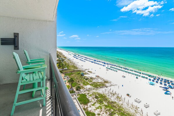 A balcony with a view of a beach with umbrellas and lounge chairs. - 🌴Gulf Front~Pools~Onsite Restaurant~Balcony~Sauna~SunDestin 1409🌴 (Destin)