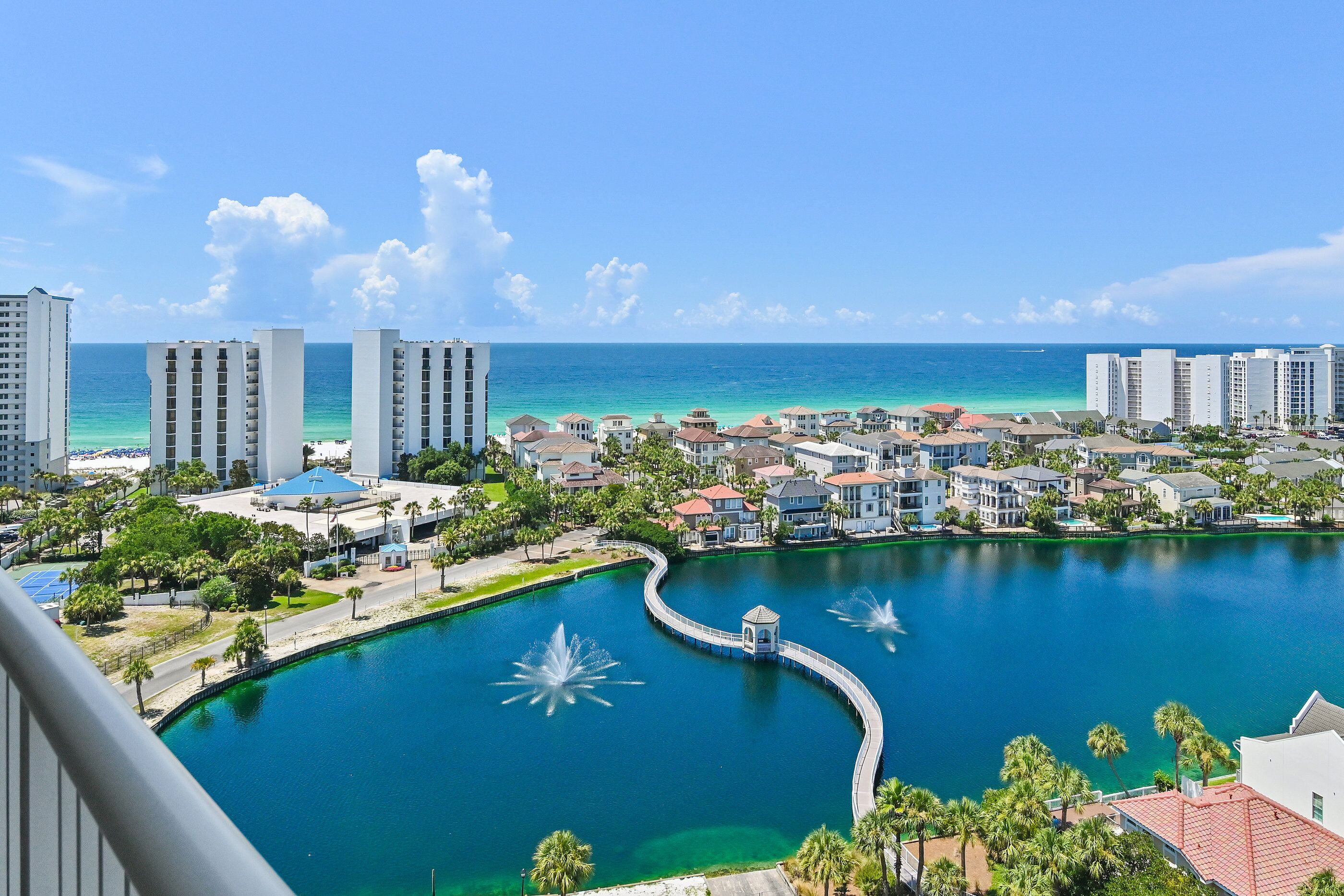 A coastal resort with a marina, buildings, and a clear view of the ocean.