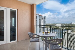 A balcony with a table and chairs, a view of a cityscape, and a building in the background. - Dream Florida Escape in Fort Lauderdale! (Fort Lauderdale)