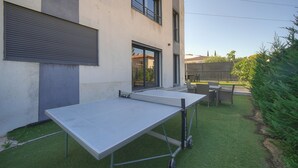 A modern building with a flat roof, a retractable garage door, and a small outdoor table with chairs. - Exceptional 9-Bedroom Villa in Mougins (Mougins)