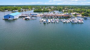 A marina with multiple docks and boats, a large blue building labeled 'Pete's Pier,' and a backdrop of a residential area with trees and hills. - HUNTER SPRINGS condo with boat dock (Crystal River)
