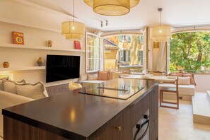 Una cocina moderna con una isla central, electrodomésticos integrados y un amplio ventanal con vistas al exterior.
