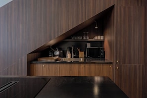 A modern kitchen with dark wood cabinetry, a black countertop, and a built-in oven. - Modern 2bdr Flat for 6P - Saint-tropez / Port (Saint-Tropez)