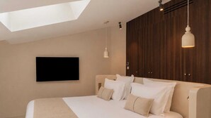 A modern bedroom with a large bed, a mounted TV, and a skylight. - Modern 2bdr Flat for 6P - Saint-tropez / Port (Saint-Tropez)
