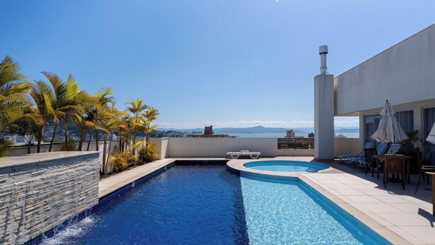 A rooftop swimming pool with a view of the city and mountains in the distance. - Apt. in Condo. w/ Pool & City View Pst1111 (Florianópolis)