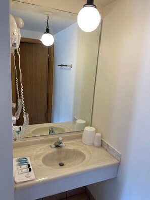 A bathroom with a sink, mirror, and hanging lights. - D-Lux budget Inn (Lemont)