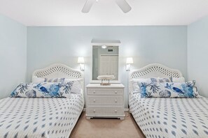 Ein Schlafzimmer mit zwei Betten, einem Schminktisch und einem Spiegel.