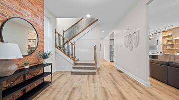 Un interior moderno con una escalera, una zona de cocina y un área de descanso.