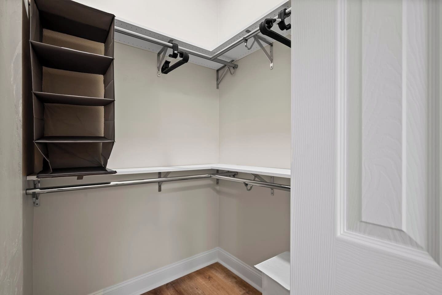 Ein begehbarer Kleiderschrank mit Einbauregalen und einer Kleiderstange.