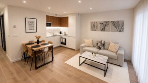 Apartamento moderno con comedor, kitchenette y sala de estar.