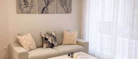 A modern living room with a sofa, a coffee table, and artwork on the wall.