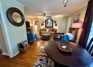A living room with a round table, a sofa, a television, and a fireplace. - Walk to Dickies&Will Rogers|Guest Suite+Game Room (Fort Worth)