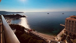 Vista costera con cielo despejado, mar tranquilo y una costa lejana.
