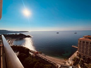 Vista costera con cielo despejado, mar tranquilo y una costa lejana.