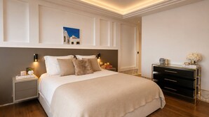 Un dormitorio moderno con una cama grande, mesitas de noche, un aparador y una obra de arte colgada en la pared.