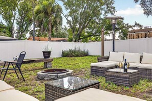 Un jardin avec des meubles d’extérieur, un foyer et un lampadaire.