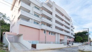 A multi-story hotel with a flat facade, balconies, and a gated entrance. - La Rosadita by LikeHome  (Bombinhas)