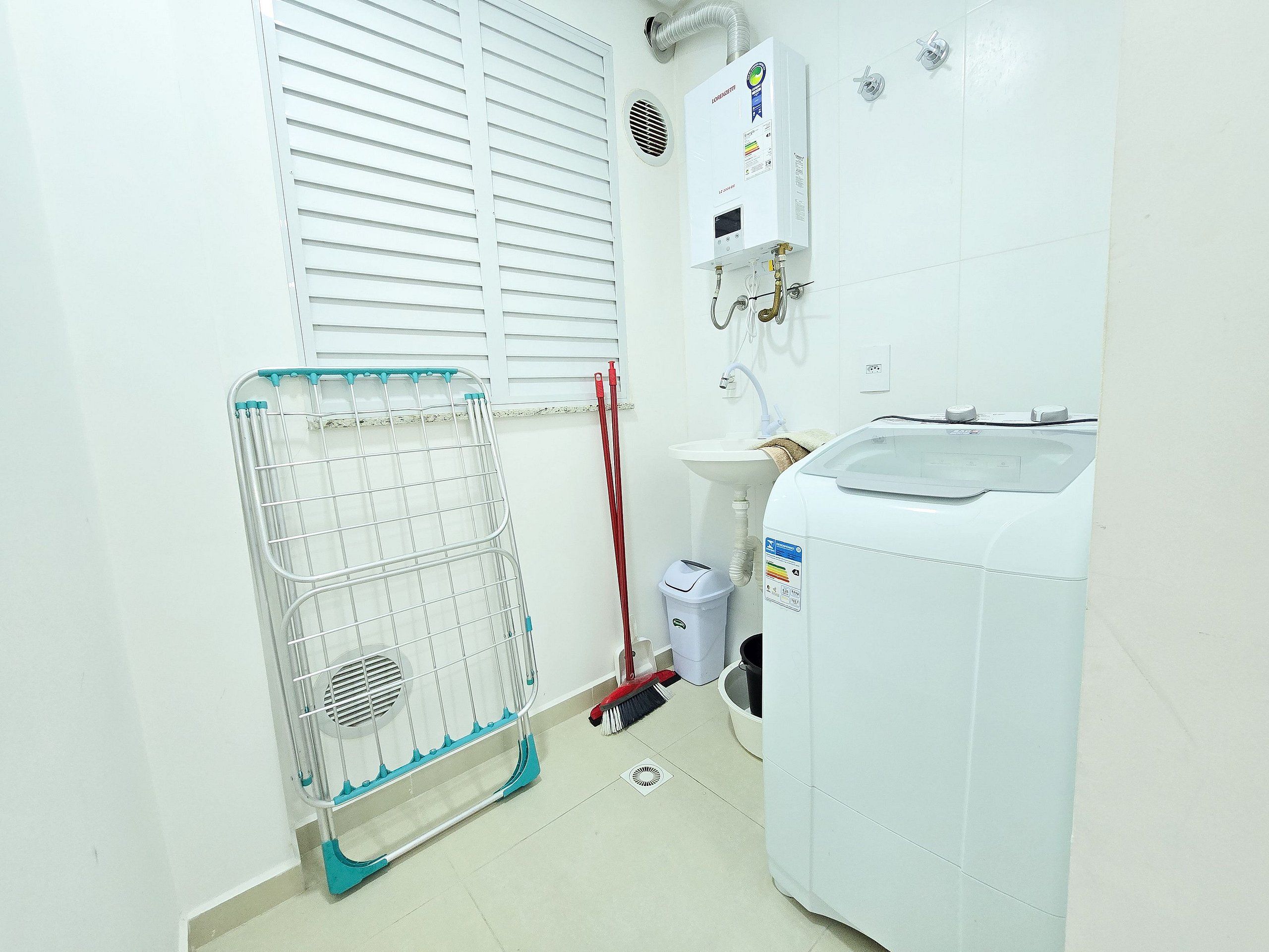 Een badkamer met een witte verwarming, een wastafel en een wasmachine.