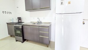A compact kitchen with a microwave, coffee maker, sink, and a refrigerator. - La Rosadita by LikeHome  (Bombinhas)
