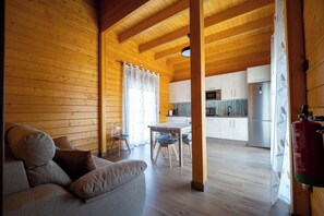 A cozy cabin interior with a wooden interior, a dining area, and a kitchen.