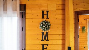 Een houten wand met de letters 'H M E' en een krans.
