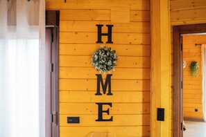 A wooden wall with the letters 'H M E' and a wreath.