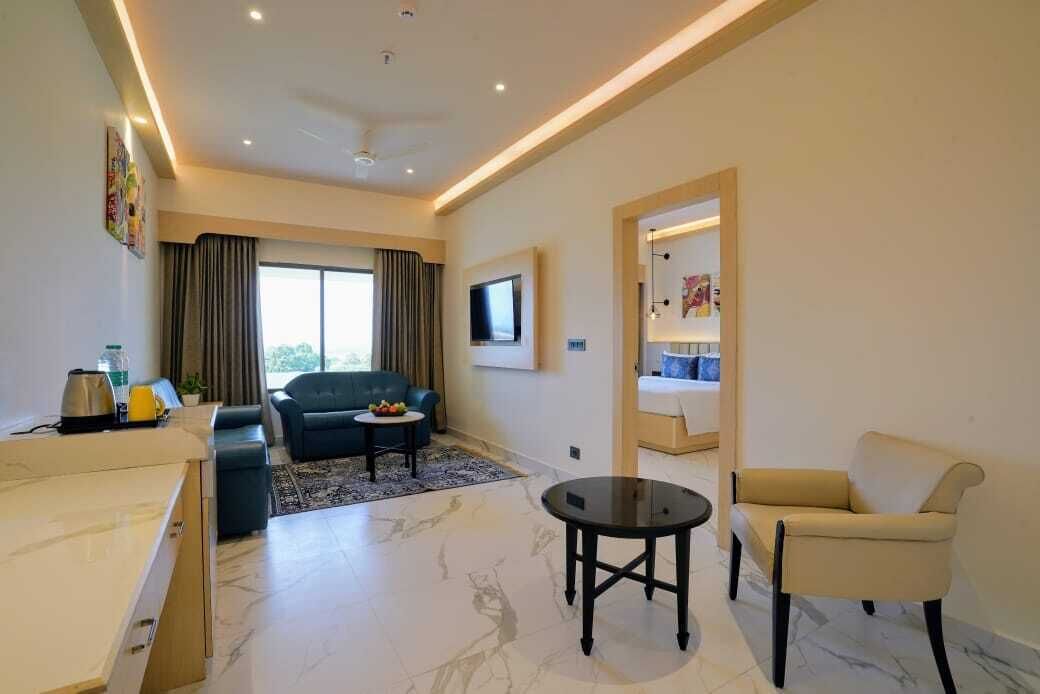 A modern living room with a sofa, a coffee table, a TV, and a dining area with a chair.