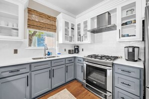 A modern kitchen with grey cabinets, a stainless steel stove, and a built-in oven. - Sugar Sand Bungalow with 3 Min Walk to Beach (Santa Rosa Beach)