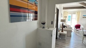 A spacious living area with a modern design, featuring a white cabinet, a dining table, and a sofa. - Elegant apartment close to the port and the market (Saint-Martin-de-Ré)