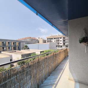 Um edifício moderno com varanda e vista para a paisagem urbana.