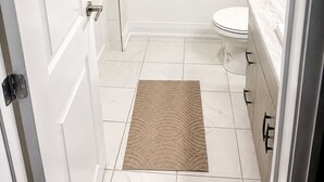 A bathroom with a toilet, a shower, and a sink.
