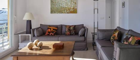 A modern living room with a grey sofa, a wooden coffee table, and a floor lamp.
