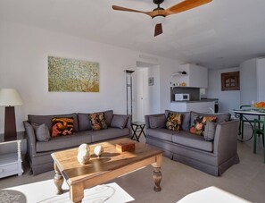 A living room with two grey sofas, a wooden coffee table, and a ceiling fan. - RicosRincones · Ocean View Apartment (San Pedro Alcántara)