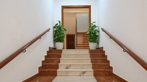 A staircase with alternating brown and beige steps leading to a door at the top. - Ocean View Apartments on Boulevard, Apartame. (San Pedro Alcántara)