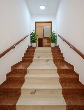 Eine Treppe mit abwechselnd braunen und beigen Stufen, die zu einer Tür am oberen Ende führt.