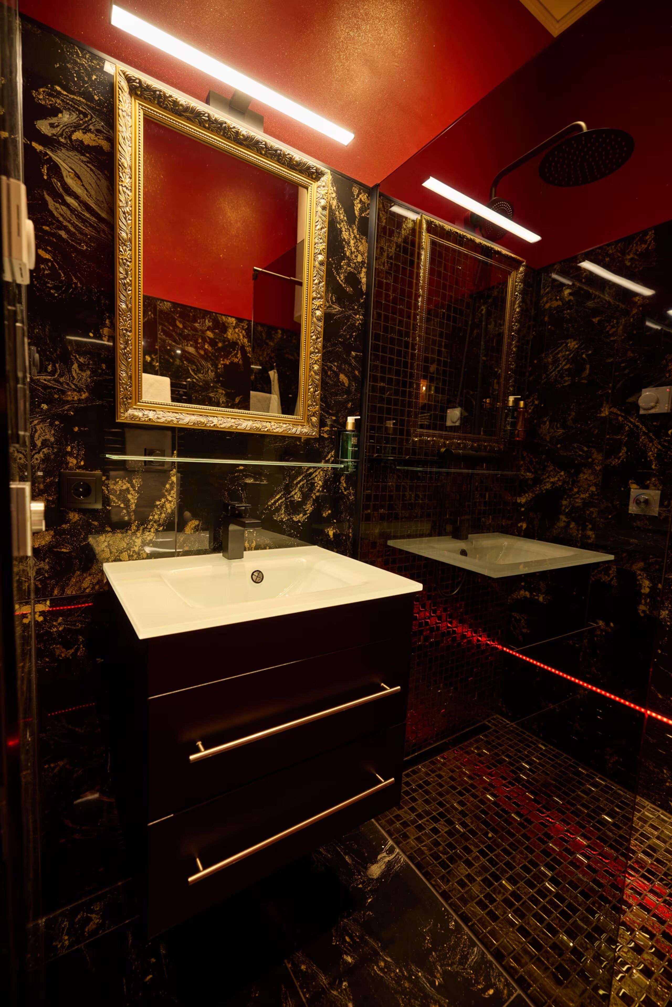 Une salle de bain avec un mur en marbre, un grand miroir et un lavabo moderne.