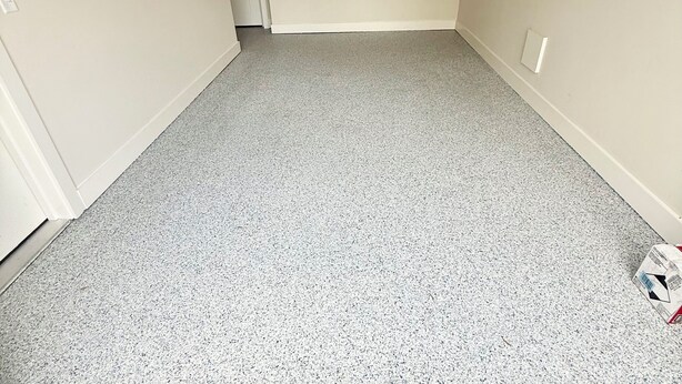 A room with a grey speckled floor, a door, and a light switch on the wall. - New Spacious 5-bedroom condo in the heart of fabulous Dewey Beach (Dewey Beach)