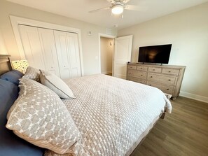 A bedroom with a bed, a dresser, a television, and a ceiling fan. - New Spacious 5-bedroom condo in the heart of fabulous Dewey Beach (Dewey Beach)