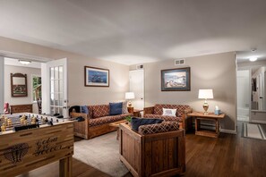 A cozy living room with a foosball table, two sofas, and a coffee table. - Right Mtn Attitude · Arcade, Hot Tub & Fire Pit (Berkeley Springs)